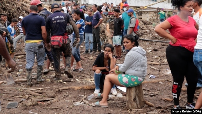 La gente mira la destrucción causada por las fuertes lluvias en Las Tejerías, Venezuela, el domingo 9 de octubre de 2022.