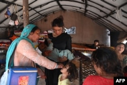 Seorang petugas kesehatan memberikan vaksin polio kepada seorang anak saat berlangsungnya kampanye vaksinasi di Lahore, Pakistan, 24 Oktober 2022. (Arif ALI / AFP)