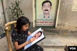 Opposition BNP leader Sajedul Islam Suman, who was abducted allegedly by RAB members in 2013, is one of the hundreds of enforced disappearance victims in Bangladesh. Suman's daughter is seen here with his photo at their Dhaka home. (Mohammad Abrar/VOA)