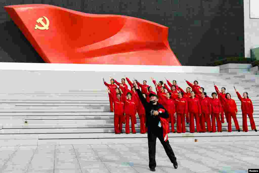 Visitors pose for a video in front of an installation of the Chinese Communist Party flag, at the Museum of the Communist Party of China in Beijing.