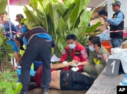 First responders attend to a victim at the site of an attack at a child care center, Oct. 6, 2022, in Nong Bua Lam Phu, province, Thailand.