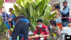 First responders attend to a victim at the site of an attack at a day care center, Oct. 6, 2022, in the town of Nongbua Lamphu, north eastern Thailand. 