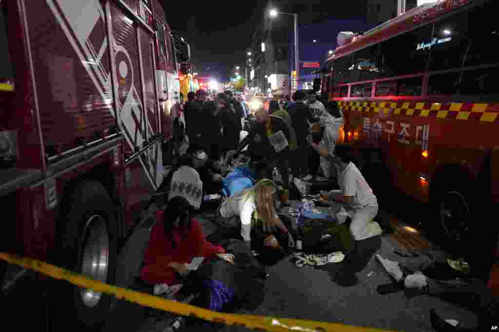 Injured people are helped at the street near the scene in Seoul, South Korea, Oct. 30, 2022. 