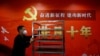 一名工作人员在北京一家酒店的中共二十大新闻中心走过宣传中国领导人习近平的标语。（2022年10月19日）