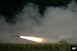 A U.S. M142 High Mobility Artillery Rocket System (HIMARS) fires a missile during annual combat drills between the Philippine Marine Corps and U.S. Marine Corps in Capas, Tarlac province, northern Philippines, Thursday, Oct. 13, 2022.