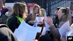 Refugees from Ukraine are seen at an application filing site at the National Stadium in Warsaw, Poland, March 19, 2022, where they receive instructions on how to apply for Polish ID numbers that will allow them to work, get free health care and gain access to education.