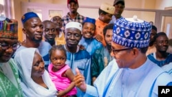 In this photo released by the Nigeria State House, Nigeria's President Muhammadu Buhari, right, meets with freed train hostages in Kaduna Nigeria, Oct. 6, 2022. 