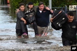 Seorang perempuan diselamatkan dari banjir di Melbourne, pinggiran Australia Maribyrnong, Jumat, 14 Oktober 2022.(Erik Anderson/AAP via AP)