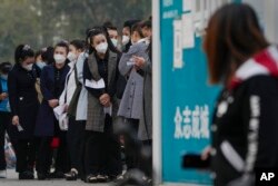 Antrean warga untuk mendapatkan tes usap tenggorokan rutin COVID-19 di tempat pengujian virus corona di Beijing, Rabu, 26 Oktober 2022. (Foto: AP)