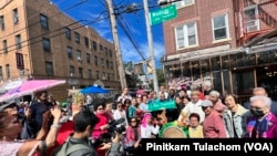 A crowd gathers beneath a street sign for the unveiling of Little Thailand Way, Saturday, Sept 24, 2022, in the Queens borough of New York.