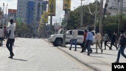 People react as they walk near one of the blast sites in Mogadishu, Somalia, Oct. 28, 2022. (Mohamed Dhaysane/VOA)