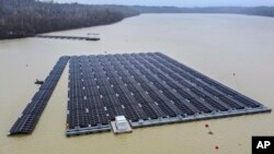 FILE - Solar panels are installed at a floating photovoltaic plant on a lake in Haltern, Germany, April 1, 2022.