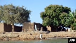 FILE - A man walks through a village at the Cameroon-Chad border, March 1, 2013. Military officials from both countries are working to free civilians taken hostage by jihadists and armed gangs.