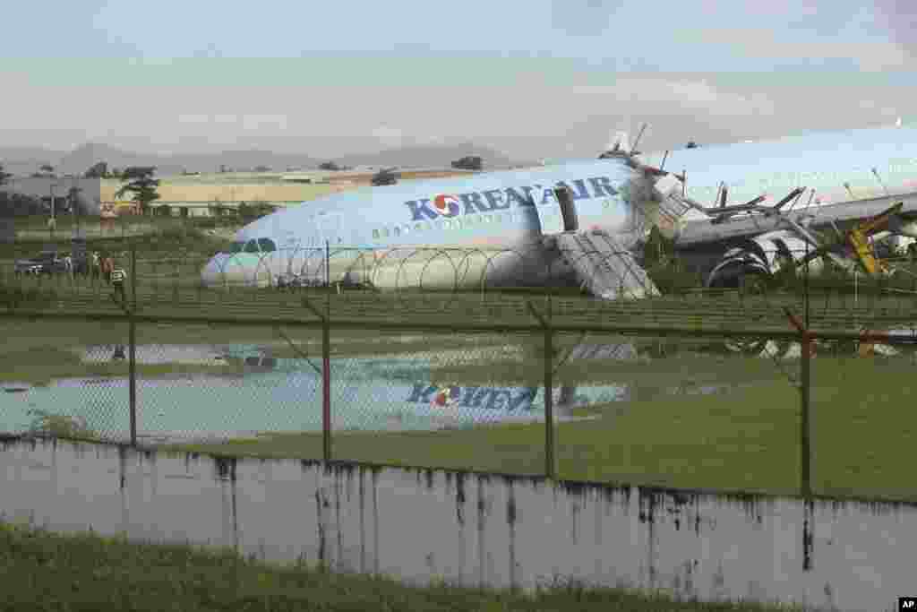 A damaged Korean Air plane sits after it overshot the runway while landing in bad weather at the Mactan-Cebu International Airport in Cebu, central Philippines. Authorities said all 173 people on board were safe.