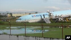 Pesawat Korean Air yang rusak masih terperangkap di rerumputan dekat landasan pacu di Bandara Internasional Mactan-Cebu di Cebu, Filipina tengah, 24 Oktober 2022.