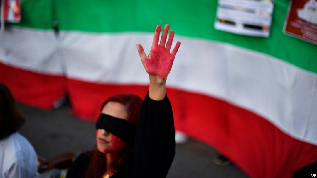 A woman raises her hand with red paint during a demonstration in support of Iranian women on Oct. 4, 2022, in Barcelona following the death of Kurdish Iranian woman Mahsa Amini in Iran.