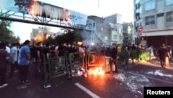 FILE - Demonstrators light a fire during a protest over the death of Mahsa Amini while in custody of Iran's morality police, in Tehran, Sept. 21, 2022. (West Asia News Agency via Reuters)