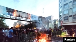 Demonstrators light a fire during a protest over the death of Mahsa Amini while in custody of Iran's "morality police," in Tehran, Sept. 21, 2022. (West Asia News Agency via Reuters)