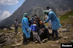 FILE - In this photo taken by Sanna Irshad Mattoo, a health care worker administers a dose of CoviShield, a coronavirus disease vaccine, to a shepherd man during a vaccination drive in Lidderwat, located in India Kashmir's Anantnag district, June 10, 2021.