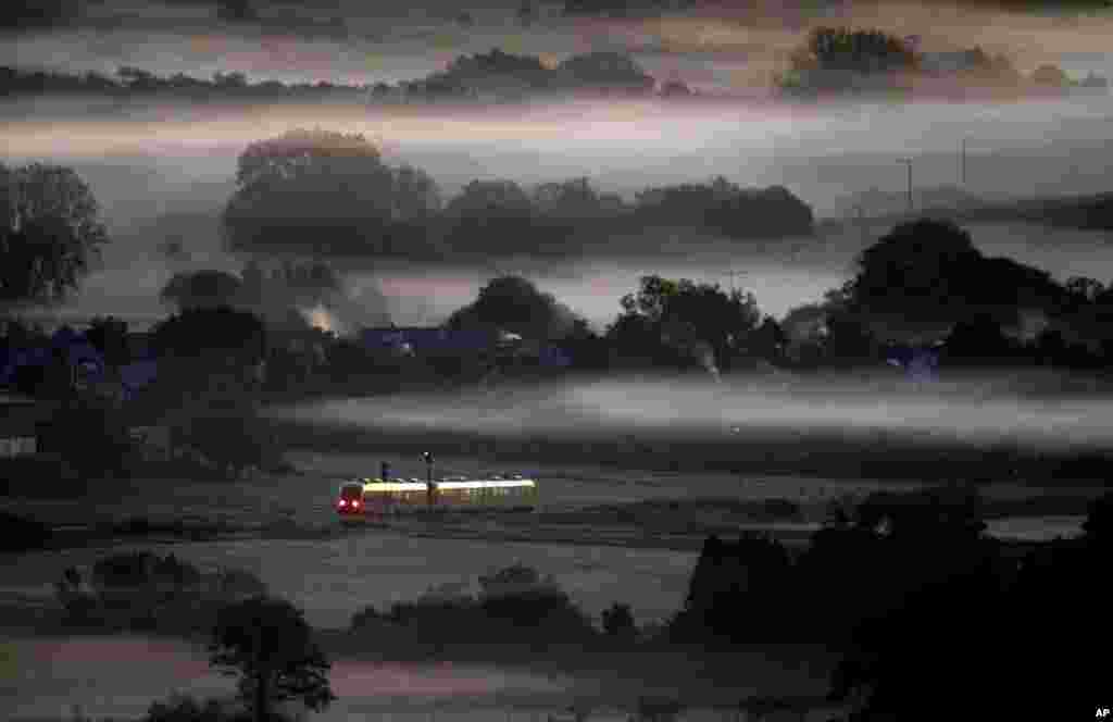 A regional train passes fog-covered fields in Wehrheim near Frankfurt, Germany.