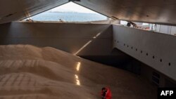 FILE - A crew member prepares a grain analysis onboard a ship coming from Ukraine loaded with grain and anchored in Istanbul, on Oct. 11, 2022.