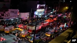 FILE - Ambulances and rescue workers arrive near the scene in Seoul, South Korea, Oct. 30, 2022.