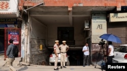Media and policemen stand outside the office of Popular Front of India (PFI) Islamic group, in New Delhi, Sept. 28, 2022. 