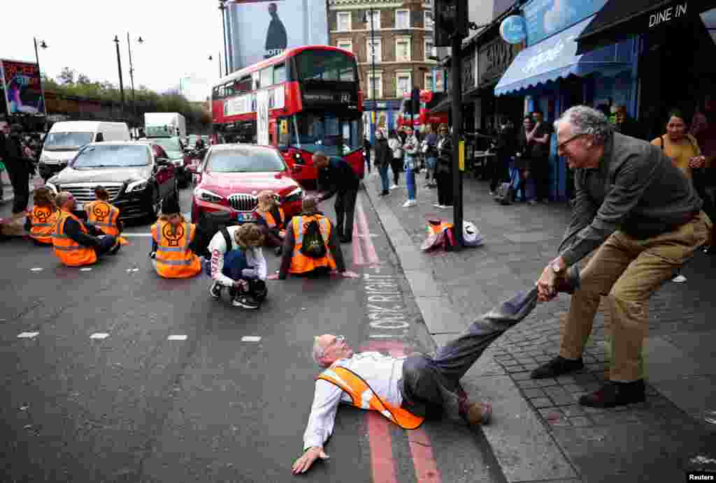 A member of the public drags an activist who is blocking the road during a &quot;Just Stop Oil&quot; protest, in London, Oct. 15, 2022.