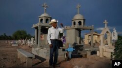 Guillermo Rojo, ayah dari Tomas, tokoh masyarakat Yaqui yang dibunuh, berdoa di dekat pusara anaknya yang dihiasi dengan salib berwarna biru di sebuah pemakaman di Potam, Meksiko, pada 27 September 2022. (Foto: AP/Fernando Llano)