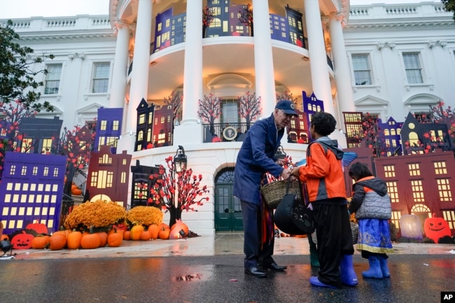 FILE - President Joe Biden and first lady Jill Biden give treats to trick-or-treaters on the South Lawn of the White House, on Halloween, Oct. 31, 2022, in Washington. (AP Photo/Alex Brandon)