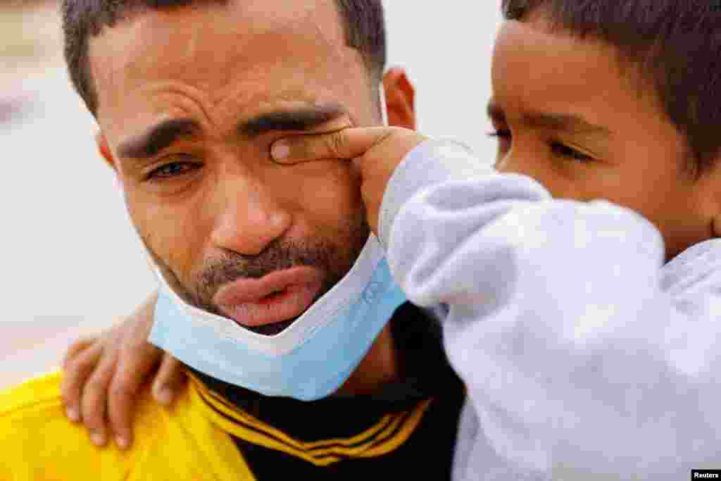 Saul, 4, wipes the tears of his father Franklin Pajaro, after they were expelled from the U.S. and sent back to Mexico under Title 42, near the Paso del Norte International border bridge, in Ciudad Juarez, Mexico, Oct. 17, 2022. 