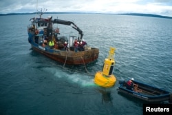 Workers place a buoy to help avoid ship collisions with whales at the 'Corcovado' gulf area in the coast of Chiloe, Chile, October 10, 2022. (Fundacion MERI/Handout via REUTERS)