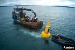 Workers spot  a buoy to assistance   debar  vessel  collisions with whales astatine  the 'Corcovado' gulf country  successful  the seashore  of Chiloe, Chile, October 10, 2022. (Fundacion MERI/Handout via REUTERS)