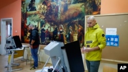 Election committee members set up voting machines at the opening of the polling stations in Sofia, Bulgaria, Oct. 2, 2022.