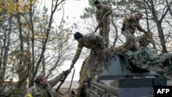 2022年10月28日，乌克兰炮兵部队成员在赫尔松地区外向赫尔松俄军开火后返回阵地。（法新社照片）
