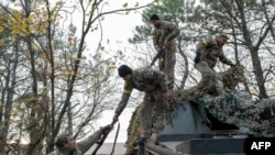 FILE - Ukrainian artillery unit members turn back to their position after fire toward Kherson on Oct. 28, 2022, outside Kherson region, amid Russia's military invasion on Ukraine.