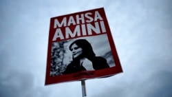 Seorang perempuan mengacungkan poster dengan foto Mahsa Amini dalam demo memprotes kematian Amini usai ditahan polisi moral Iran, di Berlin, Jerman, 28 September 2022. (Foto: Markus Schreiber/AP Photo)