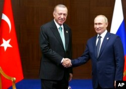 Presiden Rusia Vladimir Putin, kanan, dan Presiden Turki Recep Tayyip Erdogan berjabat tangan di Astana, Kazakhstan, Kamis, 13 Oktober 2022. ( Foto: melalui AP)