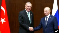 Russia's President Vladimir Putin, right, and Turkey's President Recep Tayyip Erdogan shake hands during their meeting on sidelines of the Conference on Interaction and Confidence Building Measures in Asia (CICA) summit, in Astana, Kazakhstan, Oct. 13, 20