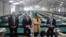New York City Emergency Management Commissioner Zach Iscol, far right, and other officials talk with reporters in the sleeping area of the city's latest temporary shelter on Randall's Island, Oct. 18, 2022.