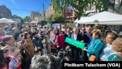 Don Pramudwinai, Thailand's Deputy Prime Minister and Minister of Foreign Affairs holds a “Little Thailand Way" street sign during the street co-naming ceremony.