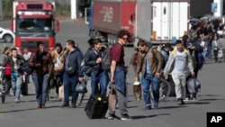 A group of Russians walk after crossing the border at Verkhny Lars between Georgia and Russia in Georgia, Sept. 27, 2022. After President Vladimir Putin ordered a partial mobilization to bolster his troops in Ukraine, many Russians are leaving their homes.