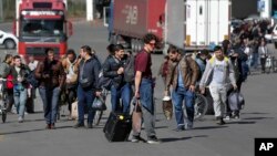 A group of Russians walk after crossing the border at Verkhny Lars between Georgia and Russia in Georgia, Sept. 27, 2022. After President Vladimir Putin ordered a partial mobilization to bolster his troops in Ukraine, many Russians are leaving their homes