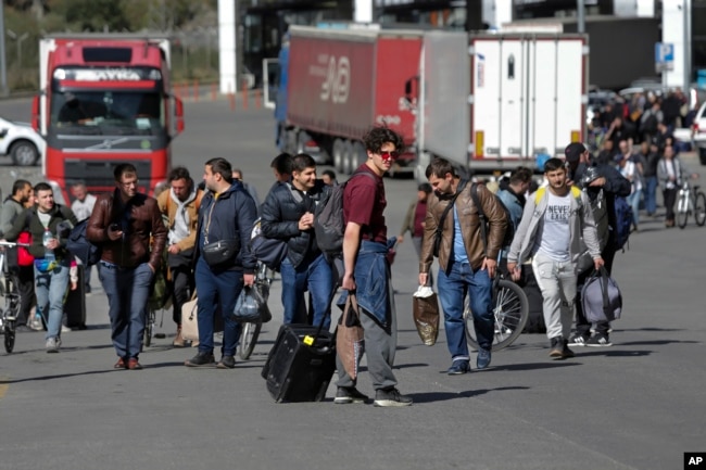 FILE - A group of Russians walk after crossing the border at Verkhny Lars between Georgia and Russia in Georgia, Sept. 27, 2022. Long lines of vehicles formed at a border crossing between Russia's North Ossetia region and Georgia after Moscow announced a partial military mobilization.