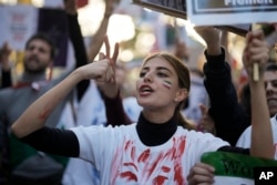 A woman shouts during a protest against the Iranian regime, in Berlin, Germany, Oct. 22, 2022, following the death of Mahsa Amini in the custody of the Islamic republic's notorious "morality police."