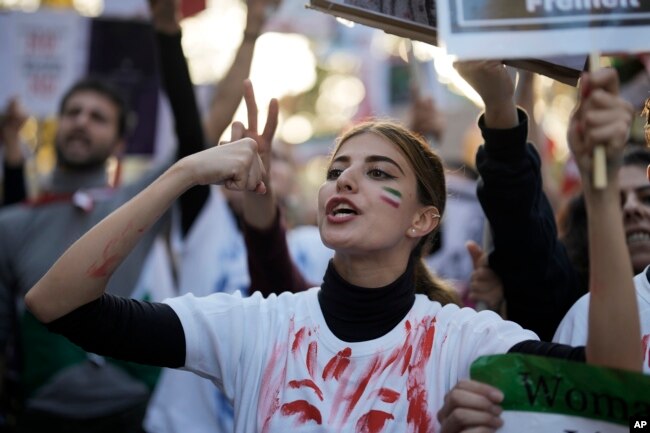 A woman shouts during a protest against the Iranian regime, in Berlin, Germany, Oct. 22, 2022, following the death of Mahsa Amini in the custody of the Islamic republic's notorious "morality police."