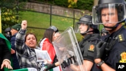 Policías hacen guardia mientras manifestantes se reúnen frente a la embajada de Irán en Oslo, Noruega, el jueves 29 de septiembre de 2022, para protestar por la muerte de Mahsa Amini, de 22 años, bajo custodia en Irán después de que fuera detenida por la policía moral del país.