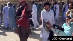 FILE - This screenshot of a video sent to VOA Persian appears to show residents of Zahedan, Iran, carrying a man with bloodstained clothing, Sept. 30, 2022. Human rights groups said 66 civilians were slain and scores were injured inside and outside a mosque in the city. (UGC)