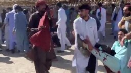FILE - This screenshot of a video sent to VOA Persian appears to show residents of Zahedan, Iran, carrying a man with bloodstained clothing, Sept. 30, 2022. Human rights groups said 66 civilians were slain and scores were injured inside and outside a mosque in the city. (UGC)