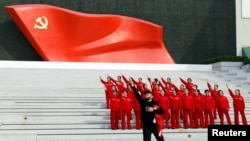 北京的中国共产党历史展览馆内参观者在中共党旗下摆姿势拍照。（2022年10月13日）